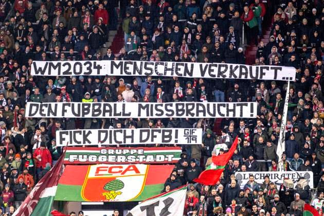 14.12.2024, Fussball 1. Bundesliga 2024 2025, 14. Spieltag, FC Augsburg - Bayer Leverkusen, in der WWK-Arena Augsburg, Proteste der Augsburger Fans gegen die WM-Vergabe an Saudi Arabien 2034: WM 2034 Menschen verkauft¦ den Fussball missbraucht, Fick Dich DFB!