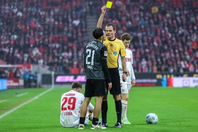 Fußball 2. Bundesliga 16. Spieltag 1. FC Köln - 1. FC Nürnberg am 15.12.2024 im RheinEnergieStadion in Köln Schiedsrichter Dr. Robin Braun( Wuppertal ), rechts - zeigt Berkay Yilmaz ( Nürnberg ), links - die gelbe Karte DFL regulations prohibit any use of photographs as image sequences and or quasi-video.