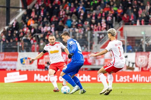 22.12.2024, Fussball, GER, Saison, 2.Liga, Saision 2024 2025, 17. Spieltag, SSV Jahn Regensburg - SV Darmstadt 98 Philipp Förster gegen Andreas Geipl (SSV Jahn) und Bryan Hein (SSV Jahn) DFL REGULATIONS PROHIBIT ANY USE OF PHOTOGRAPHS AS IMAGE SEQUENCES AND OR QUASI-VIDEO. Regensburg Bayern Deutschland Jahnstadion Regensburg