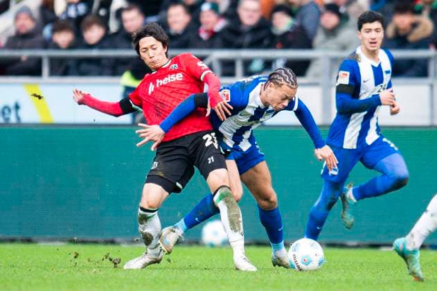 22.12.2024 - Fußball, 2024 2025, 2. Bundesliga, 17. Spieltag, Hannover 96 - Hertha BSC Berlin: (L-R) Sei Muroya (Hannover), Derry Scherhant (Berlin) DFL REGULATIONS PROHIBIT ANY USE OF PHOTOGRAPHS AS IMAGE SEQUENCES AND OR QUASI-VIDEO. Hannover Niedersachsen Deutschland Heinz von Heiden Arena