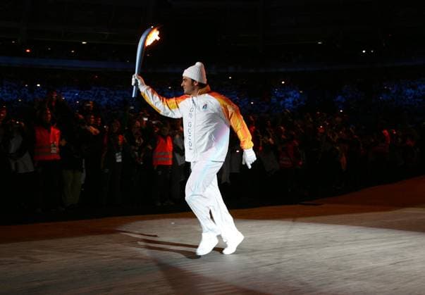 Italian Olympic legend Alberto Tomba carries the Olympic torch into Olympic Stadium during opening ceremonies for the 2006 Winter Olympics Friday, February 10th, 2006 at in Turin, Italy. (Barbara Johnston Philadelphia Inquirer KRT) Turin ITA EDITORIAL USE ONLY Copyright: xx BarbaraxL.xJohnstonx krtphotos314630
