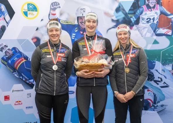 photographer: FIL Michael Kristen 28.12.2024 Tyrolean Championships, Olympia Ice Track Innsbruck-Igls, Tirol, Austria (AUT), Award Ceremony, Women™s Singles, picture: Lisa Schulte (AUT, 2nd place), Madeleine Egle (AUT, 1st place), Barbara Allmaier (AUT, 3rd place)