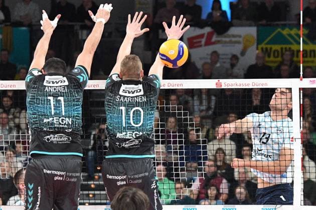 v.li.: Michael Andrei (Powervolleys Düren, 11), Tomi Saarinen (Powervolleys Düren, 10) mit missglücktem Block gegen Matti Burmann (ASV Dachau, 13) , 29.12.2024, Düren (Deutschland), Volleyball, 1. Bundesliga Männer, SWD Powervolleys Düren - ASV Dachau