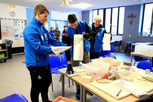 DEU, DVV, 1.VBL, BR Volleys , Stadtmission, 08.01.2025, Stadtmission Berlin, Berlin, DEU, DVV, 1.VBL, BR Volleys , Stadtmission, im Bild Spieler und Trainer helfen in der Stadtmission Trainer Joel Banks (BR Volleys), Johannes Tille (BR Volleys 6), Moritz Reichert (BR Volleys 15) Foto: Juergen Engler nordphoto GmbH