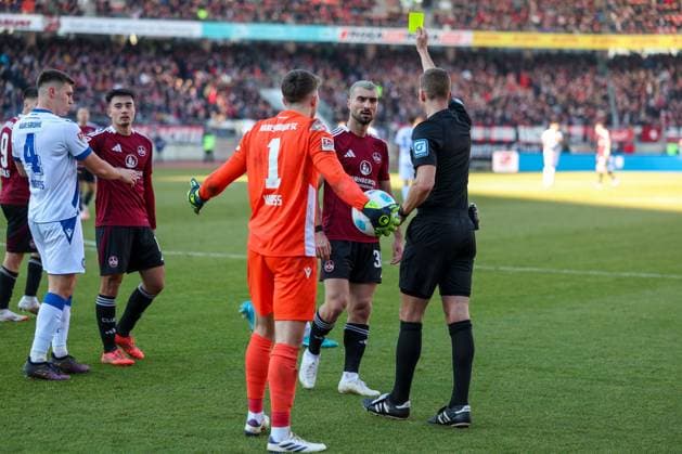 Mahir Emreli 30 (1.FC Nuernberg) und Max Weiss 1 (Karlsruher SC) gehen aufeinander los und bekommen Gelb von Schiedsrichter, Referee, Soeren Storks, 1. FC Nuernberg vs. Karlsruher SC, Fussball, 2. Bundesliga, 18. Spieltag, 19.01.2025 DFB regulations prohibit any use of photographs as image sequences and or quasi-video Nuernberg Bayern Deutschland