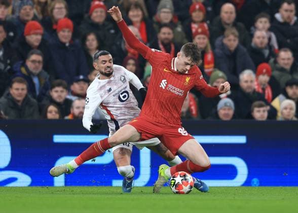 Liverpool, England, 21st January 2025. Liverpool s Conor Bradley with Lille™s Remy Cabella during the UEFA Champions League match at Anfield, Liverpool. Picture credit should read: Jessica Hornby Sportimage EDITORIAL USE ONLY. No use with unauthorised audio, video, data, fixture lists, club league logos or live services. Online in-match use limited to 120 images, no video emulation. No use in betting, games or single club league player publications. SPI_036_JH_Liverpool_Lille SPI-3613-0028