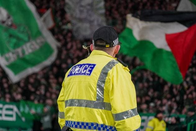 Fussball: UEFA Champions League 2024 2025, Spieltag 7 - Celtic Glasgow vs. Young Boys Bern (YB) - Celtic Park (Glasgow, Schottland): Polizist vor dem Fanblock der Celtic Fans, die u.a. eine Palästina Fahne schwenken. Copyright: xJOERANxSTEINSIEKx