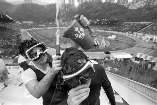 Sevens enthusiasts Dave Harris and Mark Johnson solve an underwater beer-drinking problem at the Cathay Pacific Hongkong Bank Invitation Sevens in Hong Kong Stadium. Hong Kong Hong Kong EDITORIAL USE ONLY  Copyright: xx MER1502161337436681 MarkxRoundx 0795502096st