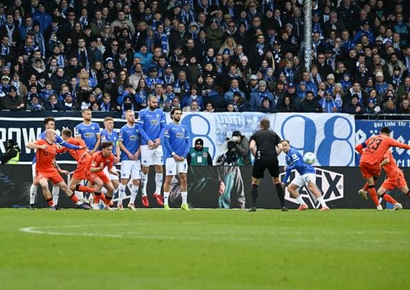 26.01.2025, xsltx, Fussball 2.Bundesliga, SV Darmstadt 98 - SC Paderborn 07 emspor, v.re. Raphael Obermair (SC Paderborn 07) prüft per Freistoß die Darmstädter Mauer und Torhüter Marcel Schuhen (SV Darmstadt 98) (DFL DFB REGULATIONS PROHIBIT ANY USE OF PHOTOGRAPHS as IMAGE SEQUENCES and or QUASI-VIDEO)