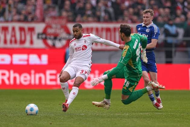 Köln, Deutschland, 09.02.25: Linton Maina (1. FC Koeln) und Torwart Justin Heekeren (FC Schalke 04) im Kampf um den Ball während des Spiels der 2. Bundesliga zwischen 1. FC Köln - FC Schalke 04 im RheinEnergieSTADION am 09. February 2025 in Köln, Deutschland. Köln RheinEnergieSTADION Germany