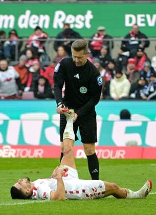 09.02.2025, xjpx, Fussball 2.Bundesliga, 1.FC Koeln - FC Schalke 04 v.l. Schiedsrichter Tobias Welz als Physiotherapeut. Er hilft Jusuf Gazibegovic (Koeln), der einen Krampf hat (DFL DFB REGULATIONS PROHIBIT ANY USE OF PHOTOGRAPHS as IMAGE SEQUENCES and or QUASI-VIDEO) Koeln