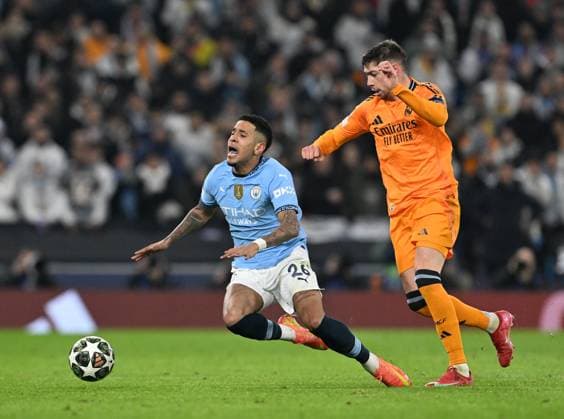 Manchester, England, 11th February 2025. Manchester City s Savinho with Real Madrid™s Federico Valverde during the UEFA Champions League match at the Etihad Stadium, Manchester. Picture credit should read: Cody Froggatt Sportimage EDITORIAL USE ONLY. No use with unauthorised audio, video, data, fixture lists, club league logos or live services. Online in-match use limited to 120 images, no video emulation. No use in betting, games or single club league player publications. SPI_CF_089_Man_City_Real_Madrid SPI-3675-0151