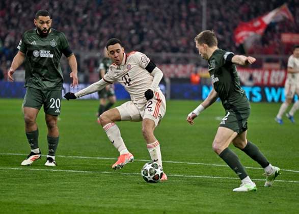 18.02.2025, Fussball UEFA Championsleague 2024 2025: Play-off Rückspiel, FC Bayern München - Celtic Glasgow, in der Allianz-Arena München. c.l. Cameron Carter-Vickers (Celtic Glasgow) gegen Jamal Musiala (FC Bayern München)