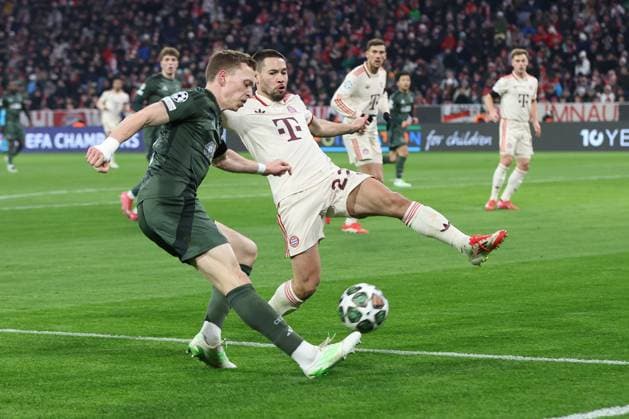 im Zweikampf, Aktion, mit Alistair Johnston 2 (Celtic Glasgow), Raphael Guerreiro 22 (FC Bayern Muenchen), FC Bayern Muenchen vs. Celtic Glasgow, Fussball, Champions League, Play offs, Rueckspiel, 18.02.2025 Muenchen Bayern Deutschland