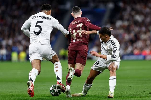 Phil Foden of Manchester City under pressure from Jude Bellingham of Real Madrid and Dani Ceballos of Real Madrid Real Madrid v Manchester City, UEFA Champions League, Knockout Round Play-offs, Second Leg, Football, Santiago BernaboÆ?Ã?Æ?o Ã? u, Madrid, Spain - 19 Feb 2025 EDITORIAL USE ONLY No use with unauthorised audio, video, data, fixture lists, club league logos or live services. Online in-match use limited to 120 images, no video emulation. No use in betting, games or single club league player publications.  Copyright: xRubenxAlbarran Shutterstockx 15137179aa