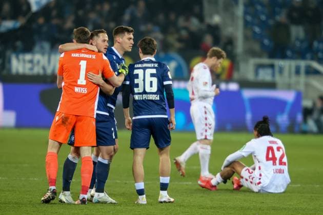Max Weiss (Karlsruher SC, Torwart 01) feiert nach Abfiff Damion Downs (1. FC Koeln, 42) am Boden, Karlsruher SC vs. 1. FC Koeln Fussball, 2. Bundesliga, 24. Spieltag, 2024 2025, 01.03.2025, DFL REGULATIONS PROHIBIT ANY USE OF PHOTOGRAPHS AS IMAGE SEQUENCES AND OR QUASI-VIDEO, Karlsruher SC vs. 1. FC Koeln Fussball, 2. Bundesliga, 24. Spieltag, 2024 2025, 01.03.2025 Karlsruhe