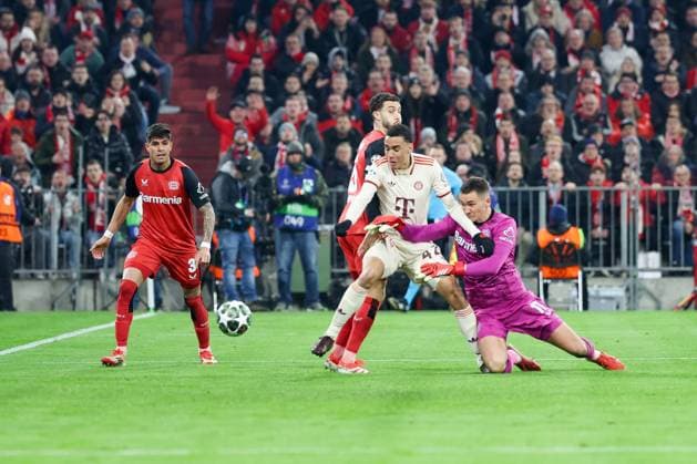 im Zweikampf, Aktion, mit Piero Hincapie 3 (Bayer 04 Leverkusen), Mario Hermoso 5 (Bayer 04 Leverkusen), Jamal Musiala 42 (FC Bayern Muenchen), Matej Kovar 17 (Bayer 04 Leverkusen), trifft das Tor zum 2:0, FC Bayern Muenchen vs. Bayer 04 Leverkusen, Fussball, Champions League, Achtelfinale, Hinspiel, 05.03.2025 Muenchen Bayern Deutschland
