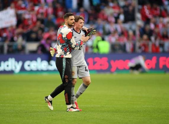 Fussball, Herren, Bundesliga, Saison 2024 2025, FC Bayern München - VFL Bochum, Allianz Arena Sven Ulreich (FC Bayern München) (li.) mit Jonas Urbig (FC Bayern München) (re.) Umarmung nach dem Spiel, Trost DFB, DFL regulations prohibit any use of photographs as image sequences and or quasi-video
