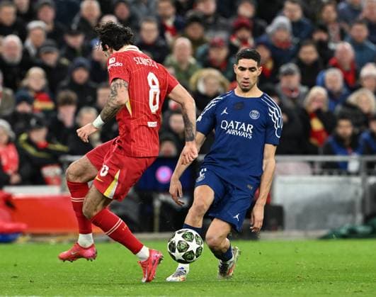 Liverpool, England, 11th March 2025. Dominik Szoboszlai of Liverpool with Achraf Hakimi of Paris St Germain during the UEFA Champions League match Liverpool vs Paris Saint Germain at Anfield, Liverpool. Picture credit should read: Cody Froggatt Sportimage EDITORIAL USE ONLY. No use with unauthorised audio, video, data, fixture lists, club league logos or live services. Online in-match use limited to 120 images, no video emulation. No use in betting, games or single club league player publications. SPI_CF_056_Man_City_Real_Madrid SPI-3739-0056