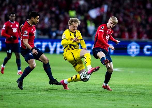 Lille, Stade Pierre Mauroy, 12.03.2025: Julian Brandt of Dortmund challenge Hakon Haraldsson during the match of the Championsleague Round 16 between Lille OSC v. Borussia Dortmund.