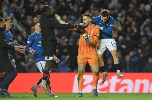 Glasgow, Scotland, 13th March 2025. Jack Butland of Rangers is mobbed by teammates after the penalty shoot out during the UEFA Europa League match Rangers v Fenerbahce at Ibrox Stadium, Glasgow. Picture credit should read: Neil Hanna Sportimage EDITORIAL USE ONLY. No use with unauthorised audio, video, data, fixture lists, club league logos or live services. Online in-match use limited to 120 images, no video emulation. No use in betting, games or single club league player publications. SPI_026_NH_Rangers_Fenerbahc__e SPI-3743-0026