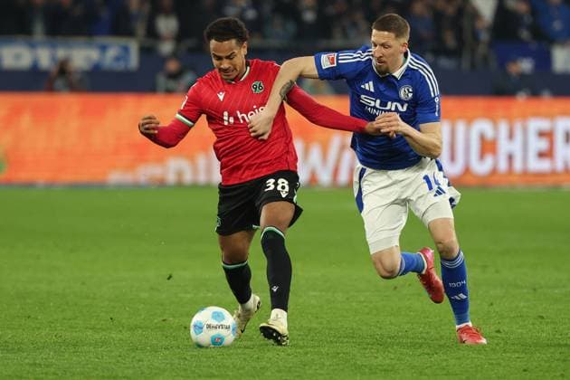 2. Bundesliga - FC Schalke 04 - Hannover 96 am 14.03.2025 in der Veltins-Arena auf Schalke Monju Thaddäus Thaddaeus Momuluh (Hannover 38) gegen Janik Bachmann (Schalke 14)