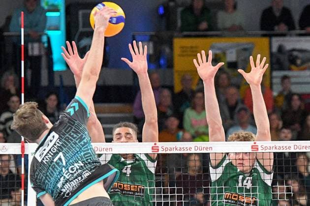 v.li.: Alex Knight (Powervolleys Düren, 7) schmettert den Ball, Kevin Kobrine (FT 1844 Freiburg, 4) und Charles Figy (FT 1844 Freiburg, 14) bei der Blockbildung, Aktion, Action, Spielszene, 14.03.2025, Düren (Deutschland), Volleyball, 1. Bundesliga Männer, SWD Powervolleys Düren - FT 1844 Freiburg