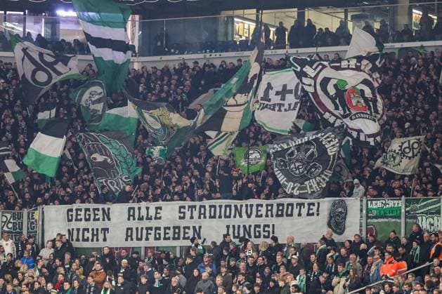 2. Bundesliga - FC Schalke 04 - Hannover 96 am 14.03.2025 in der Veltins-Arena auf Schalke Die Hannover 96 Fans schwenken im Gästeblock Fahnen und präsentieren ein Spruchband Banner - Gegen alle Stadionverbote, nicht aufgeben - Jungs