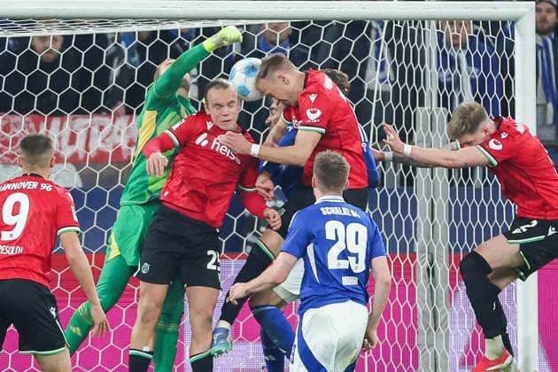 2. Bundesliga - FC Schalke 04 - Hannover 96 am 14.03.2025 in der Veltins-Arena auf Schalke Havard Nielsen (Hannover 16) erzielt gegen Torwart Loris Karius (Schalke 27) das Tor zum 1 zu 2, Nicolo Tresoldi (Hannover 9) , Lars Gindorf (Hannover 25) sowie Tobias Mohr (Schalke 29) schauen der Szenerie zu.