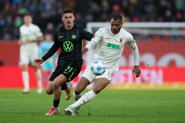 im Zweikampf, Aktion, mit Joakim Maehle 21 (VfL Wolfsburg), Steve Mounie 15 (FC Augsbburg), FC Augsburg vs. VfL Wolfsburg, Fussball, 1. Bundesliga, 26. Spieltag, 15.03.2025 DFB regulations prohibit any use of photographs as image sequences and or quasi-video Augsburg Bayern Deutschland