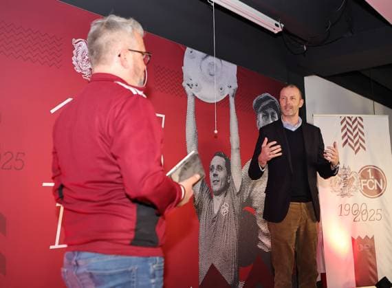 18.03.2025 - Fussball - 1. FC Nürnberg FCN ( Club ) - Kick-Off-Veranstaltung zum Jubiläum 125 Jahre 1. FC Nürnberg - Sportfoto Zink DaMa - xdaxmax - Daniell Westgate ( Team 125 Jahre Organistaion 1. FC Nürnberg FCN ) Niels Rossow ( Vorstand Strategie & Marketing 1. FC Nürnberg FCN ) sprechen zu Gästen