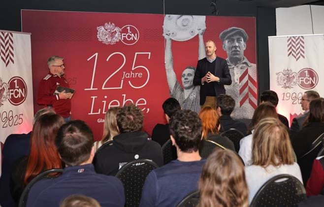 18.03.2025 - Fussball - 1. FC Nürnberg FCN ( Club ) - Kick-Off-Veranstaltung zum Jubiläum 125 Jahre 1. FC Nürnberg - Sportfoto Zink DaMa - xdaxmax - Daniell Westgate ( Team 125 Jahre Organistaion 1. FC Nürnberg FCN ) Niels Rossow ( Vorstand Strategie & Marketing 1. FC Nürnberg FCN ) sprechen zu Gästen