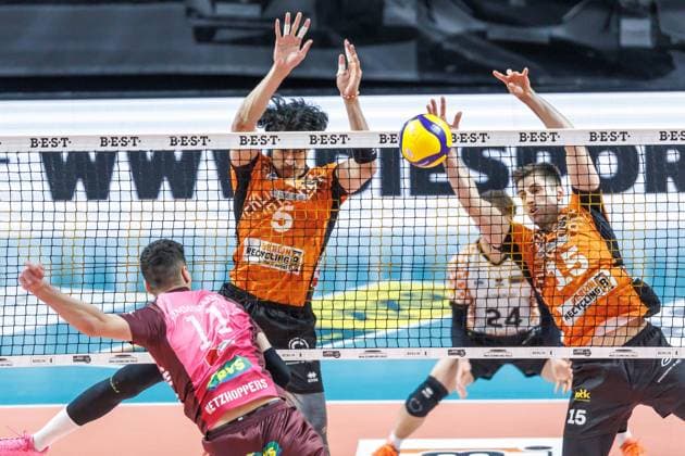 23.03.2025, Berlin, Volleyball: 1.Bundesliga, Maenner, Playoffs, Viertelfinale, 1. Spieltag, BR Volleys - Energiequelle Netzhoppers KW, Max-Schmeling-Halle. Theo Timmermann (l-r) von Netzhoppers KW spielt den Ball gegen Berlins Block aus Nehemiah Mote und Moritz Reichert. BR Volleys - Netzhoppers KW