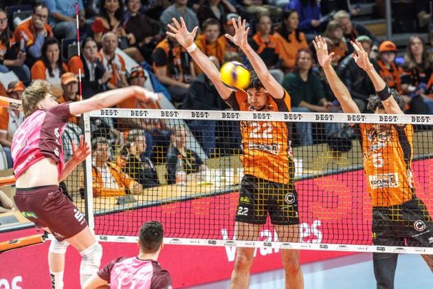 23.03.2025, Berlin, Volleyball: 1.Bundesliga, Maenner, Playoffs, Viertelfinale, 1. Spieltag, BR Volleys - Energiequelle Netzhoppers KW, Max-Schmeling-Halle. Lovis Homberg (l-r) von Netzhoppers KW spielt den Ball gegen den Block aus Berlins Jake Hanes und Nehemiah Mote. BR Volleys - Netzhoppers KW