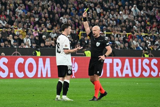23.03.2025, xsltx, Fussball UEFA Nations League, Deutschland - Italien v.l. Angelo Stiller (Deutsche Fussball Nationalmannschaft DFB) Schiedsrichter Referee Szymon Marciniak (Polen) zeigt die gelbe Karte (DFL DFB REGULATIONS PROHIBIT ANY USE OF PHOTOGRAPHS as IMAGE SEQUENCES and or QUASI-VIDEO) Dortmund