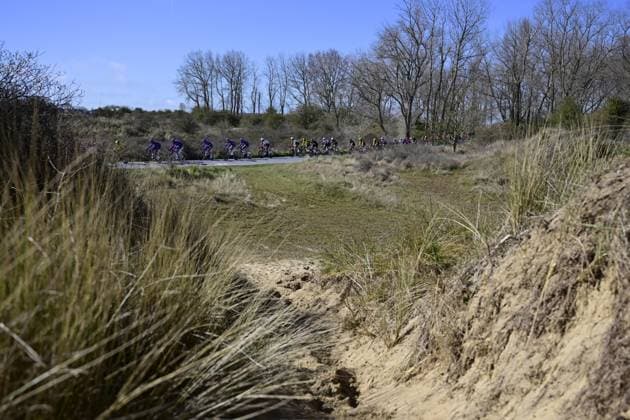 The pack of riders cross the dunes during the Classic Brugge-De Panne men s elite one-day cycling race, 195,6 km from Brugge to De Panne, Wednesday 26 March 2025. DIRKxWAEM  x115864612x
