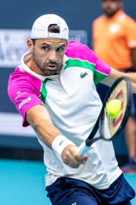 Grigor Dimitrov from Bulgaria hits a backhand shot to Novak Djokovic from Serbia in the first mens semifinal match on the stadium court at the Miami Open in the Hard Rock Stadium in Miami Gardens, Florida, on Friday, March 28, 2025. Djokovic defeated Dimitrov 6-2,6-3.  MIA20250328105 GARYxIxROTHSTEIN