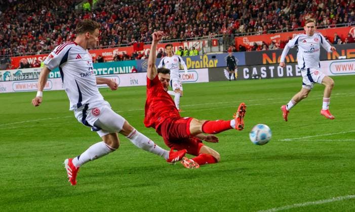 29.03.2025, xhettx, Fussball 2.Bundesliga, 1.FC Kaiserslautern - Fortuna Duesseldorf v.l. die hereingabe von Dawid Kownacki (Fortuna Düsseldorf, 24) wird von Maximilian Bauer (1. FC Kaiserslautern, 5) geblockt (DFL DFB REGULATIONS PROHIBIT ANY USE OF PHOTOGRAPHS as IMAGE SEQUENCES and or QUASI-VIDEO)