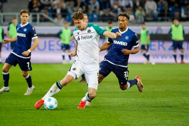 Phil Neumann (Hannover 96, 05) und Bambase Conte (Karlsruher SC, 31) im Laufduell , Deutschland, Fussball, 2. Bundesliga, .Spieltag, 2024 2025, Karlsruher SC vs. Hannover 96, 04.04.2025, BBBank Wildpark, Karlsruhe, Deutschland DFL REGULATIONS PROHIBIT ANY USE OF PHOTOGRAPHS AS IMAGE SEQUENCES AND OR QUASI-VIDEO. Karlsruhe BBBank Wildpark Baden-Württemberg Deutschland