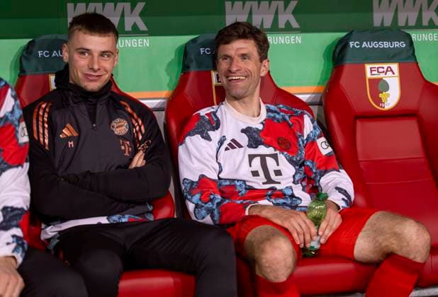04.04.2025, Fussball 1. Bundesliga 2024 2025, 28. Spieltag, FC Augsburg - FC Bayern München, in der WWK-Arena Augsburg, Thomas Müller (re, FC Bayern München) auf der Bank. li: Gabriel Vidovic (Bayern München).