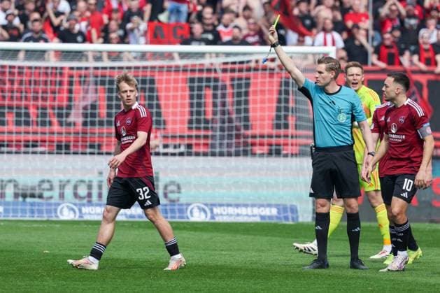 Tim Janisch 32 (1FC Nuernberg) bekommt die gelbe Karte von Referee Timo Gerach wegen Unsportlichkeit gegen Torschuetzen Jean-Luc Dompe 7 (Hamburger SV), 1. FC Nuernberg vs. Hamburger SV, Fussball, 2. Bundesliga, 28. Spieltag, 05.04.2025 DFB regulations prohibit any use of photographs as image sequences and or quasi-video