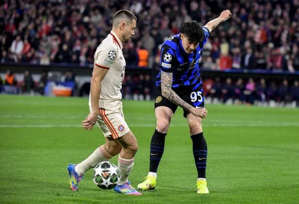 08.04.2025, xemx, Fussball UEFA Champions League, FC Bayern Muenchen - Inter Mailand v.l. Raphael Guerreiro (FC Bayern Muenchen), Alessandro Bastoni (Inter Mailand) Zweikampf, Aktion, action, battle for the ball (DFL DFB REGULATIONS PROHIBIT ANY USE OF PHOTOGRAPHS as IMAGE SEQUENCES and or QUASI-VIDEO) Muenchen