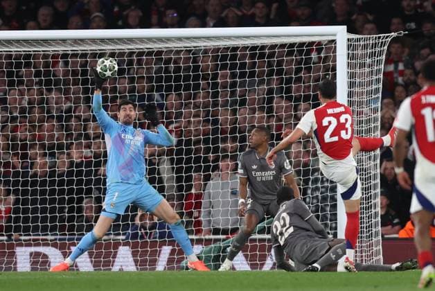 London, England, 8th April 2025. Thibaut Courtois of Real Madrid saves from Mikel Merino of Arsenal during the Arsenal vs Real Madrid UEFA Champions League match at the Emirates Stadium, London. Picture credit should read: David Klein Sportimage EDITORIAL USE ONLY. No use with unauthorised audio, video, data, fixture lists, club league logos or live services. Online in-match use limited to 120 images, no video emulation. No use in betting, games or single club league player publications. SPI_066_DK_Arsenal_Real_Madrid SPI-3819-0067