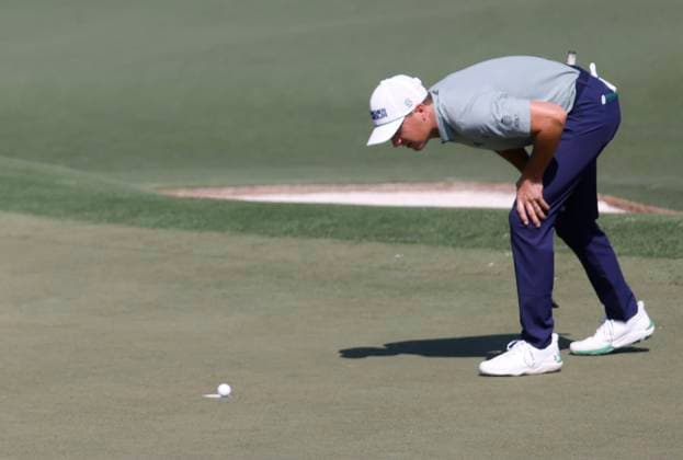 Jordan Spieth watches to see if a putt from Tom Kim of South Korea will drop into the cup on the second hole during the first round of the Masters golf tournament at Augusta National Golf Club in Augusta, Georgia on Thursday, April 10, 2025.  AUG20250410561 TANNENxMAURY