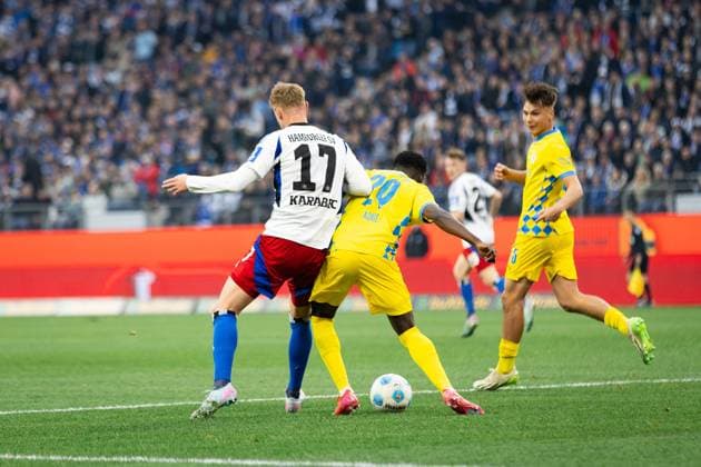 Fußball I Herren I Saison 2024-2025 I 2. Bundesliga I 29. Spieltag I Hamburger SV - Eintracht Braunschweig I 11.04.2025 Adam Karabec (17, Hamburger SV) gegen Richmond Tachie (29, Eintracht Braunschweig). Hamburg Volksparkstadion Hamburg Deutschland