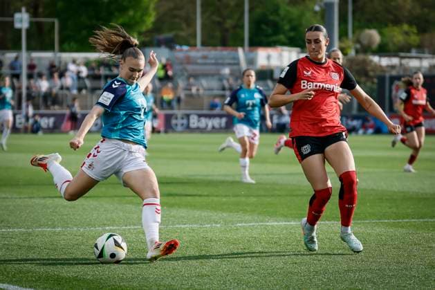 Frauen Fußball-Bundesliga; Bayer 04 Leverkusen - 1. FC Köln, 14.04.2025 Alena Bienz (1. FC Köln, 11) zieht ab, Selina Ostermeier (Bayer 04 Leverkusen, 2) schaut zu; Bayer 04 Leverkusen - 1. FC Köln an Spieltag 19 der Google Pixel Frauen-Bundesliga am 14.04.2025 im Ulrich-Haberland-Stadion in Leverkusen (Nordrhein-Westfalen). DFL REGULATIONS PROHIBIT ANY USE OF PHOTOGRAPHS AS IMAGE SEQUENCES AND OR QUASI-VIDEO. Copyright: xBEAUTIFULxSPORTS AxelxKohringx