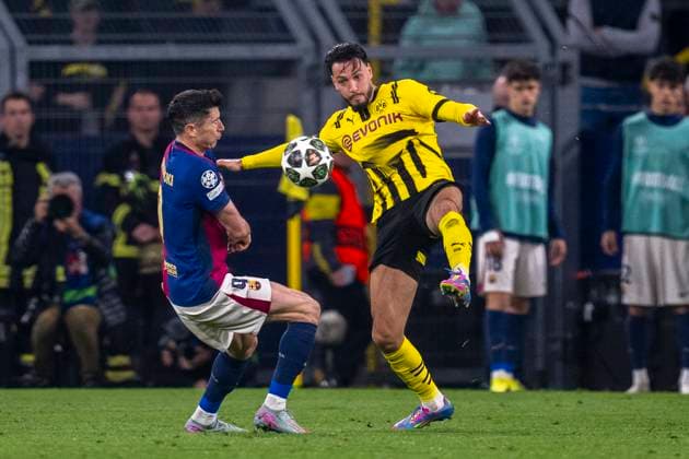 15.04.2025, Borussia Dortmund vs. FC Barcelona, Barca UEFA Champions League, Viertelfinale, Rückspiel: Barcelonas Robert Lewandowski (l) und Dortmunds Ramy Bensebaini kämpfen um den Ball. Wichtiger Hinweis: Gemaess den Vorgaben der UEFA ist es untersagt, in dem Stadion und oder vom Spiel angefertigte Fotoaufnahmen in Form von Sequenzbildern und oder videoaehnlichen Fotostrecken zu verwerten bzw. verwerten zu lassen. Copyright: xDavidxInderliedx