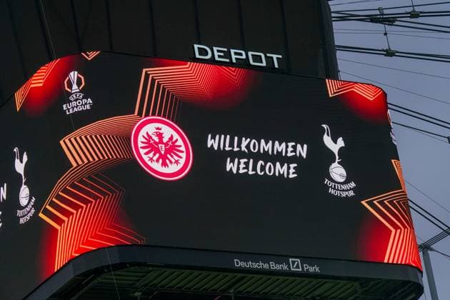 Fussball UEFA Europa League 2024 2025, Viertelfinale (Rückspiel) - Eintracht Frankfurt vs. Tottenham Hotspur - Deutsche-Bank-Park (Frankfurt): Anzeigetafel mit Begrüßung Willkommen Welcome, Logos von Eintracht Frankfurt und Tottenham Hotspur, UEFA Europa League Logo, moderne Grafik mit roten und orangefarbenen Linien, Schriftzug Depot über der Tafel, Stadiondach und Seilzüge im Hintergrund. Copyright: xJOERANxSTEINSIEKx