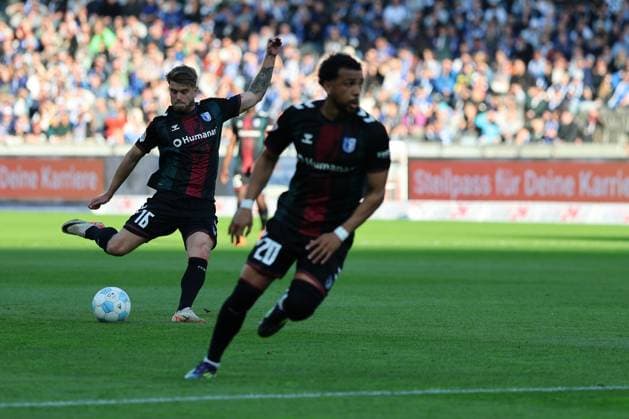 2. Fußball Bundesliga, Hertha BSC - 1. FC Magdeburg Marcus Mathisen (Magdeburg 16) beim Torschuss auf das Tor, Vorne Xavier Amaechi (Magdeburg 20), während der Begegnung in der 2. Fußball Bundesliga, Hertha BSC - 1. FC Magdeburg in Berlin, Olympiastadion, am 25.04.2025. DFB regulations prohibit any use of photographs as image sequences and or quasi video.