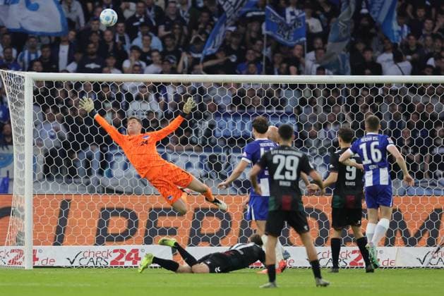 2. Fußball Bundesliga, Hertha BSC - 1. FC Magdeburg Tjark Ernst (Hertha BSC Berlin 1) hält, sichert einen Torschuss von Alexander Nollenberger (Magdeburg 17), rechts hb44 und Toni Leistner (Hertha BSC Berlin 37), während der Begegnung in der 2. Fußball Bundesliga, Hertha BSC - 1. FC Magdeburg in Berlin, Olympiastadion, am 25.04.2025. DFB regulations prohibit any use of photographs as image sequences and or quasi video.
